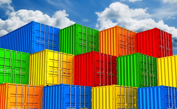 Colorful stacked freight shipping containers against clouds